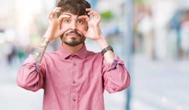 Yakışıklı delikanlı ile parmak, Uykulu ve sabah yorgunluk için yorgun gözlerini açmaya çalışırken izole arka plan üzerinde pembe gömlek giymiş