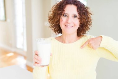 Yaşlı kadın kendini işaret sürpriz yüzü ile taze süt bir bardak içme