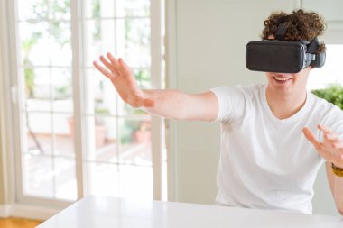 Genç adam eğleniyor evde sanal gerçeklik gözlüklü