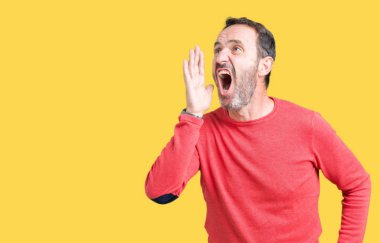 Bağırarak ve ağzı üzerinde el ile yan için çığlık izole arka plan üzerinde kış kazak giymiş yakışıklı orta yaş ağarmış komuta sizde. İletişim kavramı.