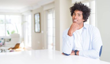 Afrika kökenli Amerikalı adam evde emin çapraz kollar ve çeneme kaldırdı el ile gülümseme ile kamera arıyorum. Pozitif düşünce.