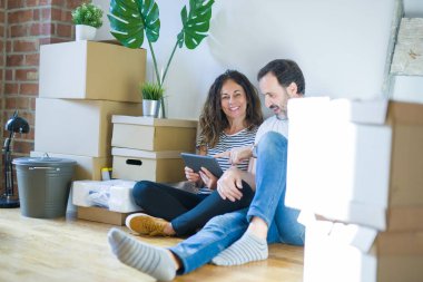 Orta yaş Senior çift yeni bir eve hareket, yeni bir ev metin ile bir tahta tutan Apartmant aşık mutlu gülümseyen