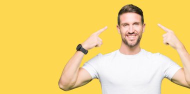 Yakışıklı adam rahat beyaz t-shirt gülen her ikisi ile baş gösteren giyen eller parmak, harika bir fikir ya da düşünce, iyi hafıza