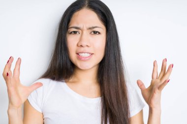 Güzel esmer kadın izole arka plan çılgın ve kızgın bağırarak ve agresif ifade ve silah kaldırdı bağırıyor. Hayal kırıklığı kavramı.