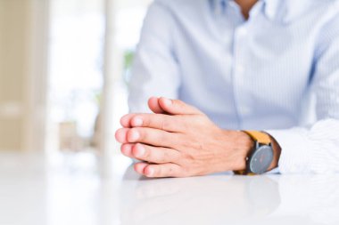 Beyaz masa üzerinde adam elleri yakın 