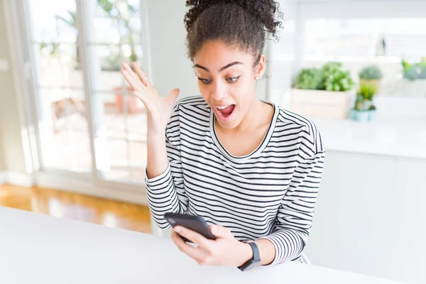 年轻的非洲裔美国妇女使用智能手机发短信非常高兴和兴奋 胜利者的表情庆祝胜利尖叫与大微笑和举手 — 图库照片