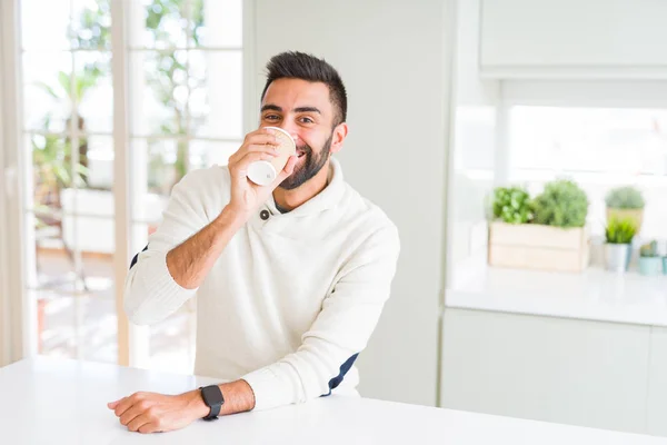 Hombre guapo sonriendo mientras disfruta bebiendo un café para llevar — Foto de Stock