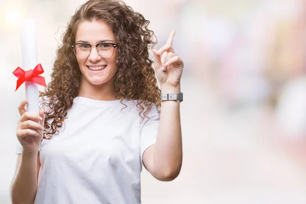 学位を保持し 眼鏡をかけて幸せな顔で ナンバーワンのアイデアや質問ポインティング指と驚かれる分離の背景の上の若いブルネットの少女 — ストック写真