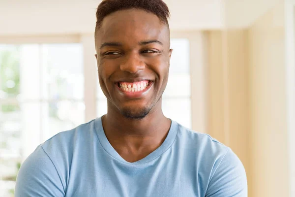 Guapo joven africano sonriendo alegre con los brazos cruzados —  Fotos de Stock