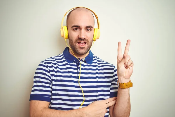 Mladý Muž Poslouchá Hudbu Která Nosí Žluté Sluchátka Izolované Pozadí — Stock fotografie