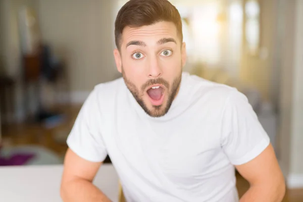 Joven Hombre Guapo Con Camiseta Blanca Casual Casa Asustado Sorprendido —  Fotos de Stock