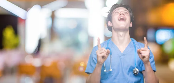Молодой Доктор Медицинской Форме Изолированном Фоне Удивлен Удивлен Глядя Вверх — стоковое фото