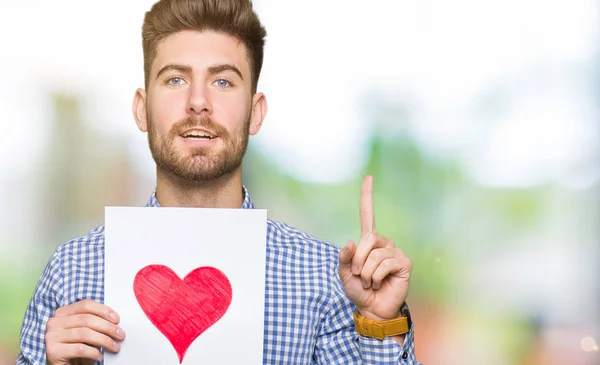 Young Handsome Man Holding Paper Red Heart Surprised Idea Question — Stock Photo, Image