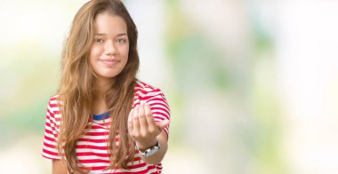 Beckoning gel burada mutlu ve gülümseyerek el davet ile jest izole arka plan üzerinde tişört giyen genç güzel esmer kadın çizgili