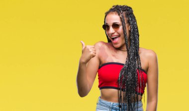 Genç örgülü saç Afrikalı-Amerikalı Doğum işareti jest el ile mutlu yaşasın yapıyor izole arka plan üzerinde güneş gözlüğü takıyor. Kameraya bakarak başarı gösteren ile ifade onaylama.