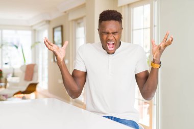 Yakışıklı afro-amerikan adam evde deli ve deli kollarını kaldırdı ve kapalı gözleri heyecan çığlık ile başarı için deli kutluyor. Kazanan kavramı