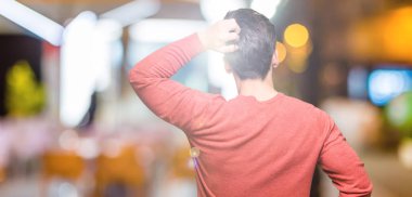 İzole arka plan geriye düşünme hakkında şüphe ile baş taraftan genç yakışıklı adam