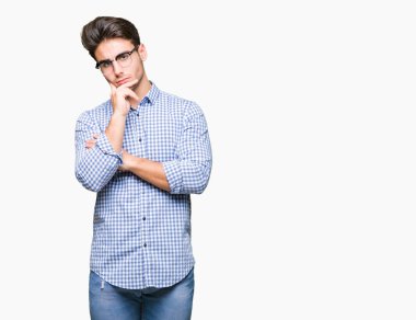 Çene düşünme hakkında soru, dalgın ifade üzerine el ile izole arka plan üzerinde gözlük takan yakışıklı delikanlı. Düşünceli yüzüyle gülümsüyor. Şüphe kavramı.
