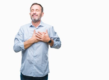 Orta yaş ağarmış üst düzey iş adamı izole arka plan ile gülümseyen üzerinde kapalı gözler ve yüzünde minnettar jest ile göğüs üzerinde eller. Sağlık kavramı.