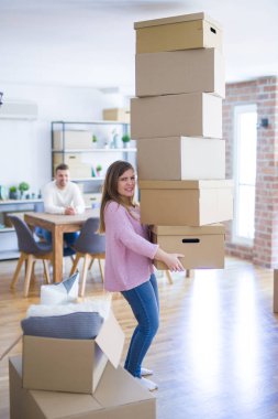 Genç çift yeni bir eve hareket, kadın karton kutular kilolu için düşen endişe tutarak