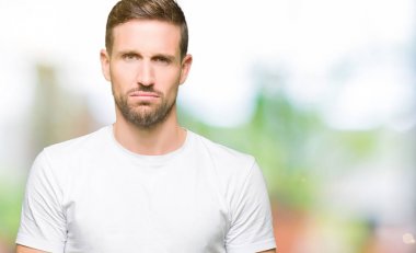 Yakışıklı adam rahat beyaz t-shirt giyen depresif ve kızgın ve korkmuş ağlıyor sıkıntı için endişeleniyorum. Üzgün ifade.