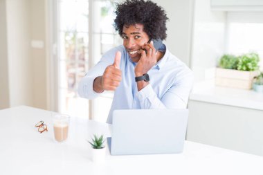 Afro-Amerikan iş adamı büyük bir gülümseme ok işareti yapıyor mutlu telefonda konuşurken, parmakları ile başparmak, mükemmel işareti