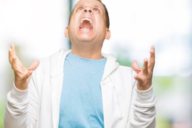 Orta Çağ Arap adam izole arka plan üzerinde Sweatshirt giyiyor çılgın ve deli bağırma ve agresif ifade ve silah ile bağırdı kaldırdı. Hayal kırıklığı kavramı.