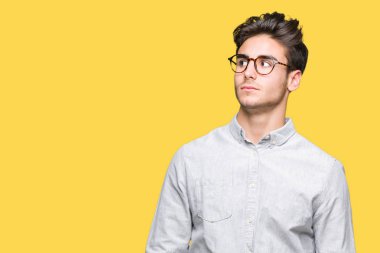 Yakışıklı delikanlı görünümlü yan ve dik dik bakma uzağa düşünce gülümseyen izole arka plan üzerinde gözlük.