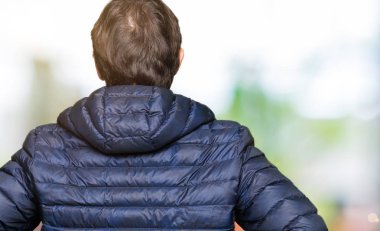 Geriye doğru uzakta silah ile vücut üzerinde seyir ayakta kış ceket giyen orta yaş yakışıklı adam