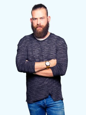 Genç sarışın adam rahat kazak şüpheci ve sinir, onaylamayan ifade yüz çapraz kollu giyiyor. Negatif kişi.