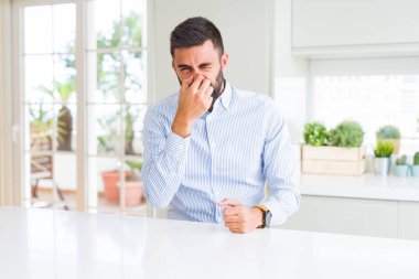 Yakışıklı İspanyol iş adamı kokuşmuş ve bir şey kokuyor, dayanılmaz kokuyor, burnunda parmaklarıyla nefes tutuyor. Kötü kokular kavramı.