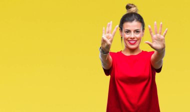 Genç güzel kadın gösterilen ve parmakları ile işaret izole arka plan üzerinde numara 9 kendinden emin ve mutlu gülümseyerek süre.