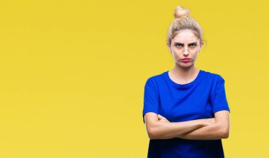 İzole arka plan şüpheci ve sinir, onaylamayan ifade yüz çapraz kolları üzerinde mavi t-shirt giyen genç güzel sarışın ve mavi gözlü kadın. Negatif kişi.