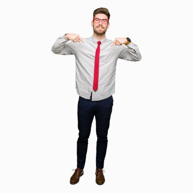 Yüzünde gülümseme ile kendinden emin görünüyorsun, kendini gururlu ve mutlu parmakları ile işaret gözlüklü genç yakışıklı iş adamı.