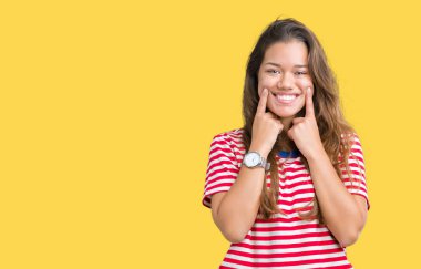 Giyen genç güzel esmer kadın çizgili tişört üzerinde izole arka plan açık ağız ile gülümseyen, işaret ve neşeli zorla parmak gülümse