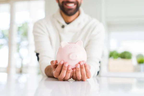 Homem sorrindo segurando seguro porquinho banco, conceito de seguro — Fotografia de Stock