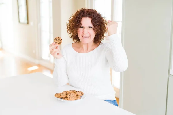 Mujer Mayor Comiendo Galletas Fritas Chocolate Casa Molesto Frustrado Gritando —  Fotos de Stock