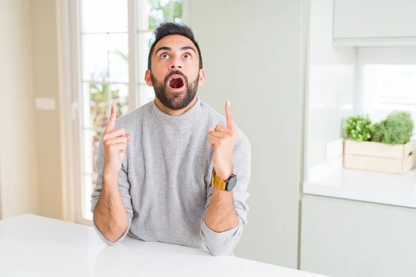 Hombre Hispano Guapo Usando Suéter Casual Casa Asombrado Sorprendido Mirando —  Fotos de Stock