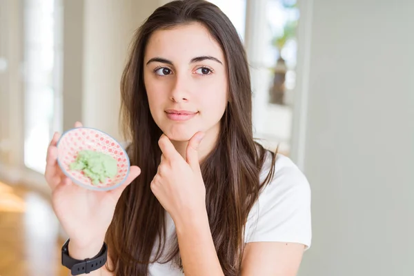 Hermosa Joven Mujer Holding Picante Asiático Wasabi Serio Cara Pensamiento — Foto de Stock