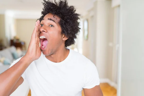 Hombre Afroamericano Casa Gritando Gritando Fuerte Lado Con Mano Boca —  Fotos de Stock