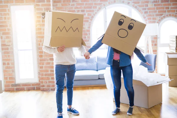 Çılgın çift kafa üzerinde komik yüzler ile kutuları giyiyor, yeni bir eve taşımak için mutlu eğlenceli
