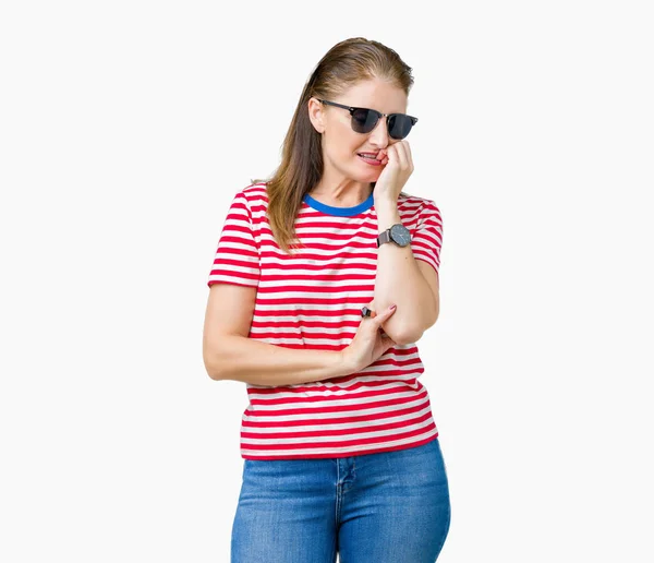 中年成熟的女人戴着太阳镜在孤立的背景看起来紧张和紧张的手在嘴咬指甲 焦虑问题 — 图库照片