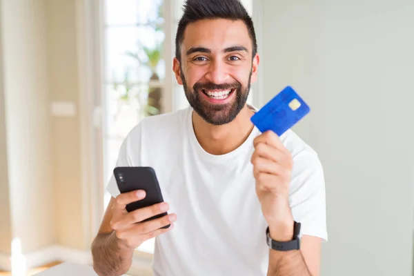 Pohledný muž používající kreditní kartu k placení smartphone — Stock fotografie