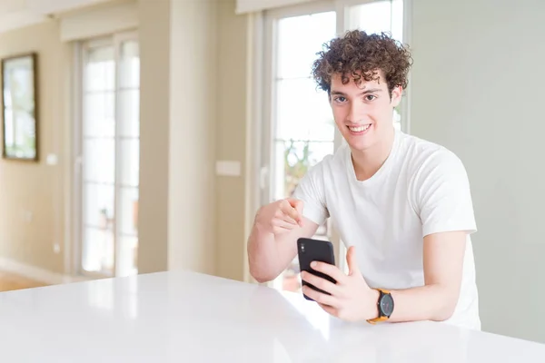 Hombre Joven Usando Teléfono Inteligente Casa Muy Feliz Señalando Con —  Fotos de Stock