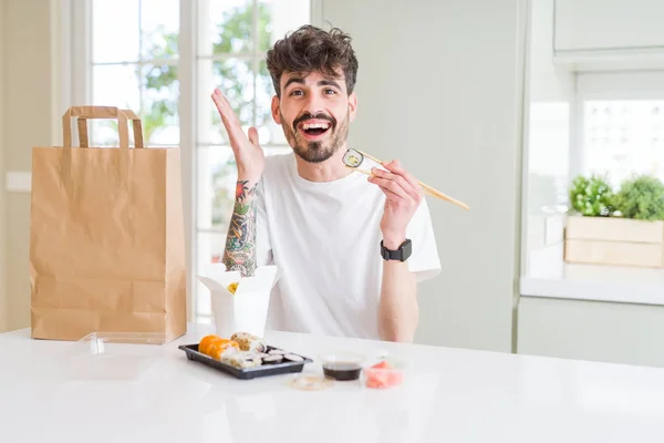 Młody Mężczyzna Jedzenie Azjatycka Sushi Dostawą Domu Bardzo Szczęśliwy Podekscytowany — Zdjęcie stockowe