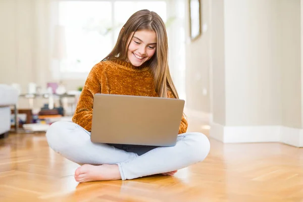 美丽的年轻女孩学习使用笔记本电脑坐在地板上在家里与一个幸福的脸站在微笑与自信的微笑显示牙齿 — 图库照片