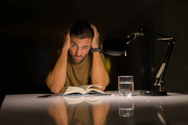 自宅で勉強する若いハンサムな男は非常に退屈でストレスの多いリア — ストック写真