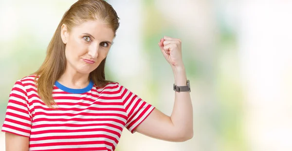 中年成熟的女人穿着休闲 T恤在孤立的背景强的人显示手臂肌肉 自信和自豪的力量 — 图库照片