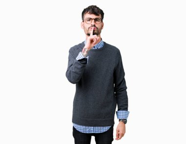Genç yakışıklı akıllı adam izole arka plan üzerinde gözlük takan dudaklarında parmak ile sessiz olmak isteyen. Sessizlik ve gizli kavram.