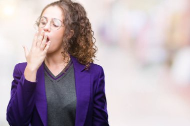 Okul üniforması ve gözlük izole arka plan üzerinde giyen genç esmer öğrenci kız esneme yorgun kapsayan ağız el ile sıkılmış. Restless ve uyku hali.